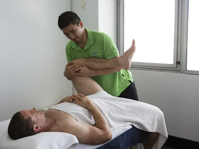 Practitioner performing an assisted hip stretch during a sports massage at Active Performance Clinic